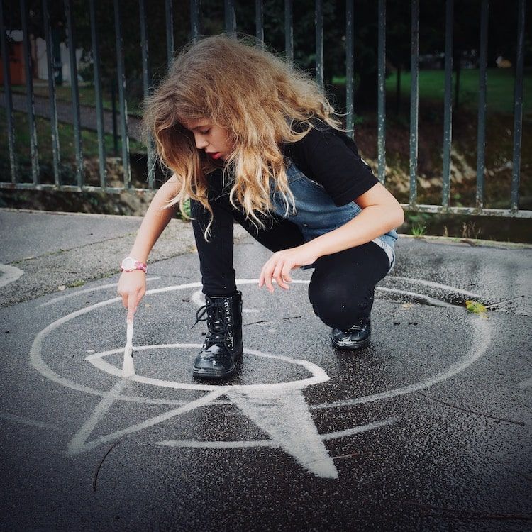 Fille de 11 dessinant sur le trottoir. Photographe enfant normandie.