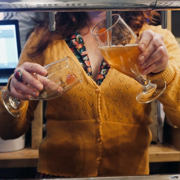 photo de bar. Femme servant des bières à la tireuse.