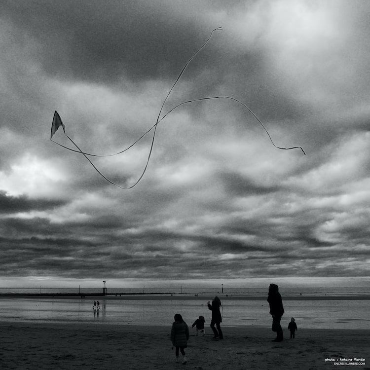 Grand cerf-volant sur la plage avec silhouette d'enfants. Photo : Antoine Fantin