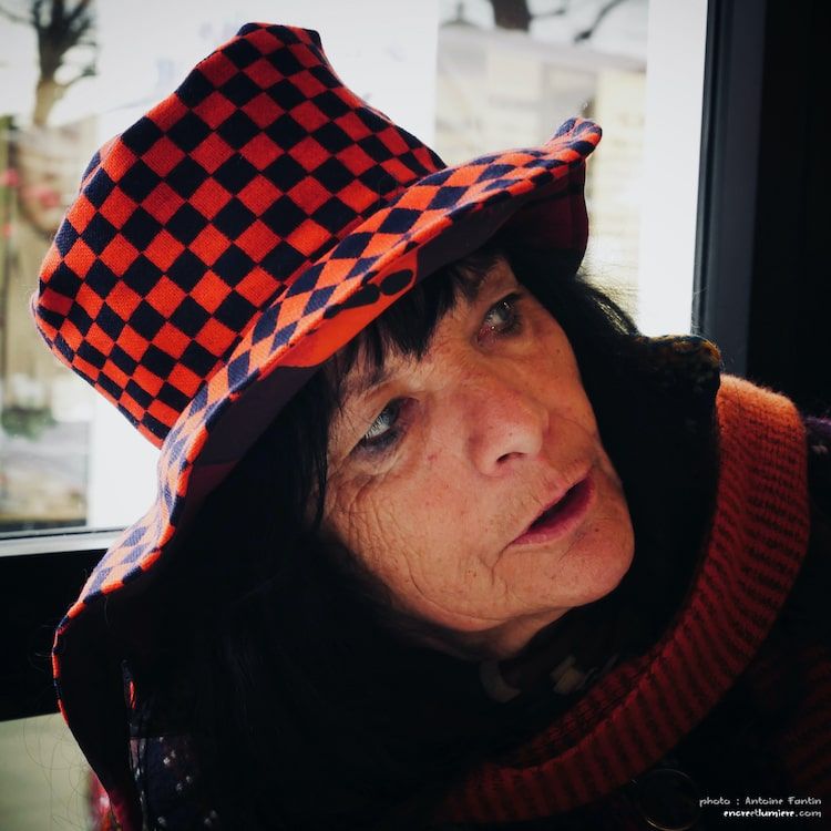 Portrait d'une femme avec un chapeau à damier rouge et noir. Photo de rue.