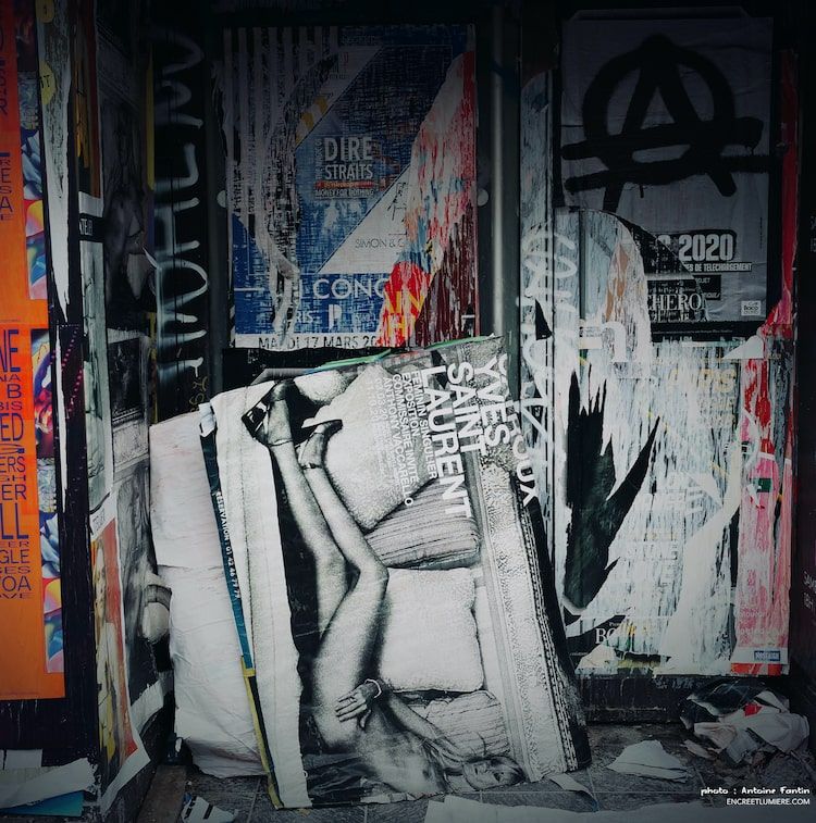 Femme à la renverse : affiche pub Yves Saint Laurent déchirée avec femme nue allongée sur un canapé.