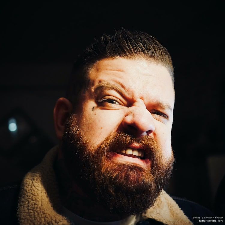 Portrait d'un homme qui fait une grimace. Photo ambiance d'Antoine Fantin. Bar : les Sœurs Pinard.