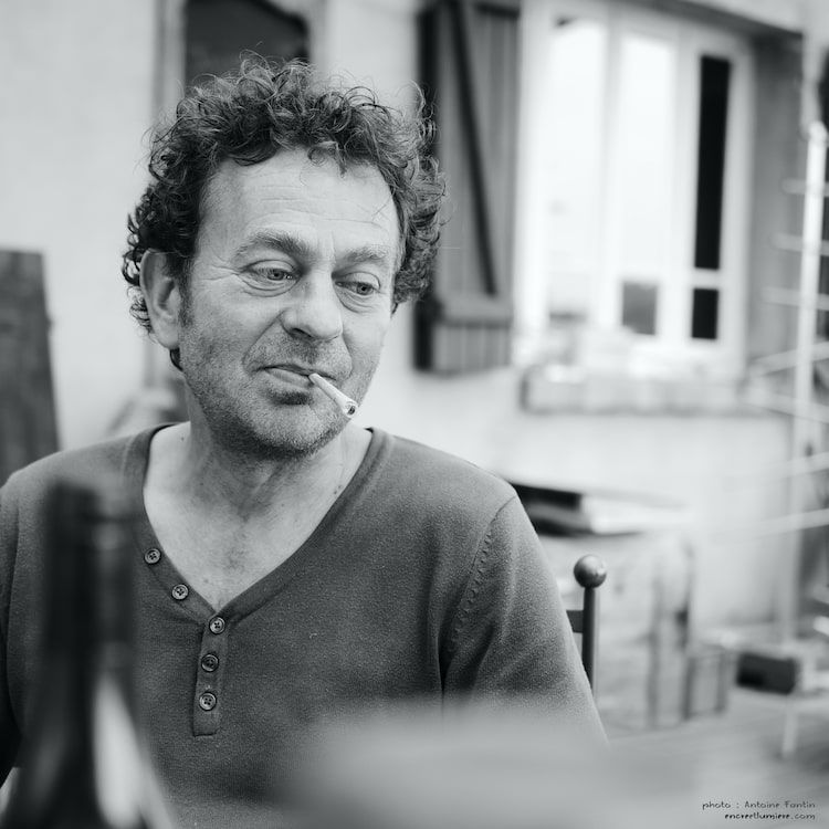 Portrait noir et blanc d'un homme nostalgique fumant une cigarette. Photographe normand, photo d'ambiance