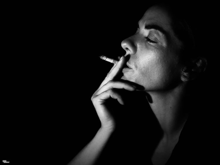 femme fumant une cigarette dans la nuit
