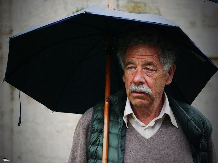 homme agé avec un parapluie