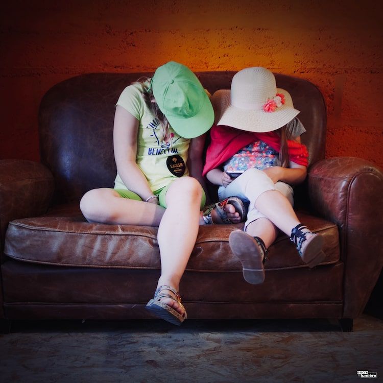 Enfants jouant avec une tablette dans un vieux canapé