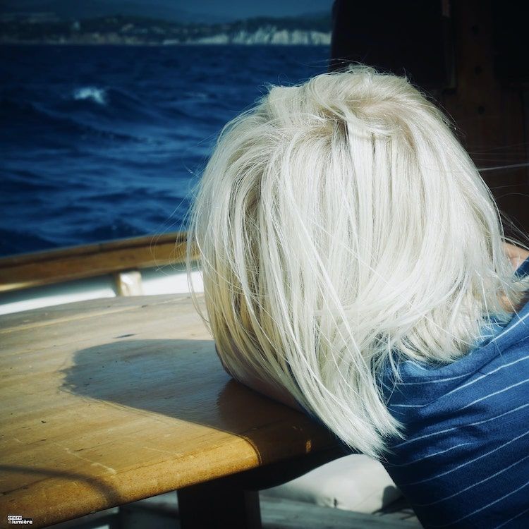 Photo enfant blond sur un bateau avec la mer Méditerranée