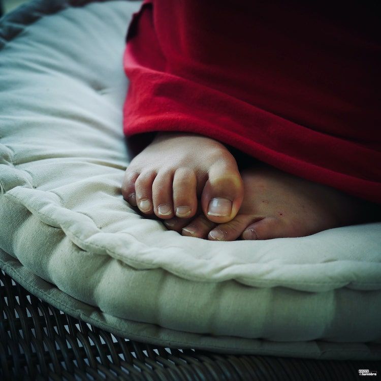 Pied d'un enfant enroulé dans une couverture.