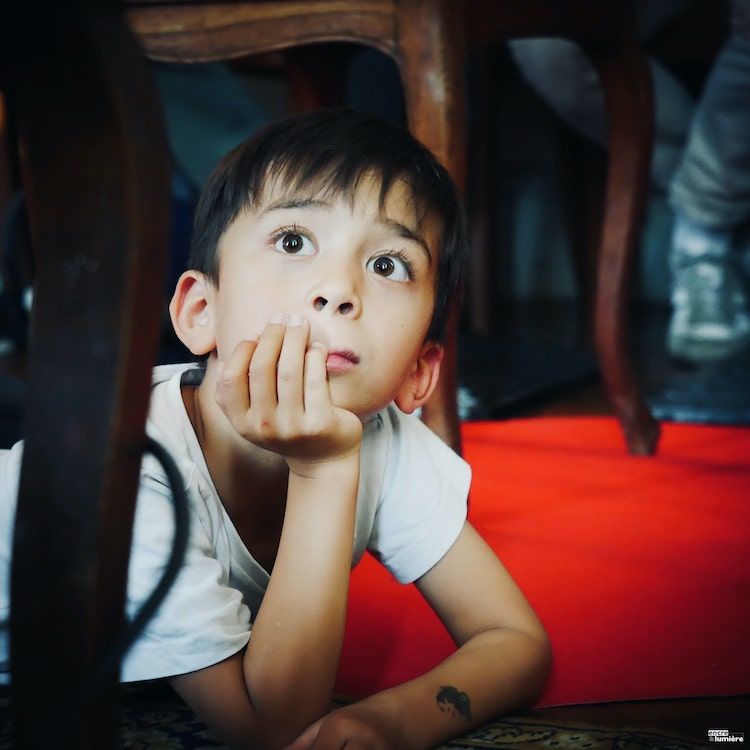 Photo d'un garçon de 7 ans aux yeux grands ouverts. Photo : Antoine Fantin "Encre & Lumière"
