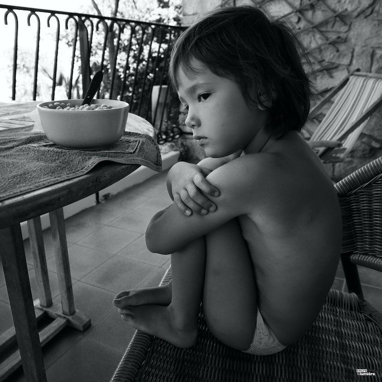 Enfant qui boude avec bol de céréales au petit déjeuné. Photo : Antoine Fantin (Encre & Lumière)