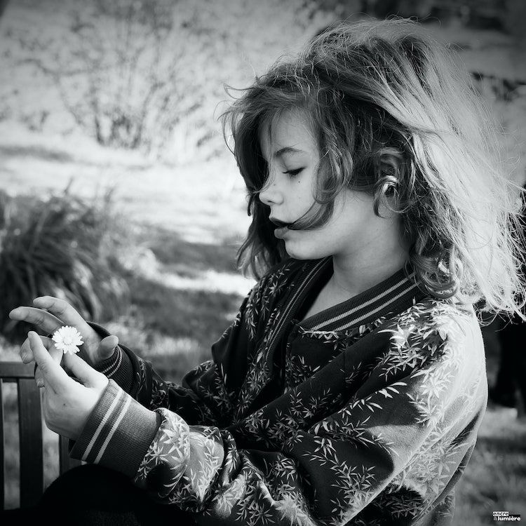 Enfant de 7 ans avec fleur dans la main. Photo : Antoine Fantin "Encre & Lumière"