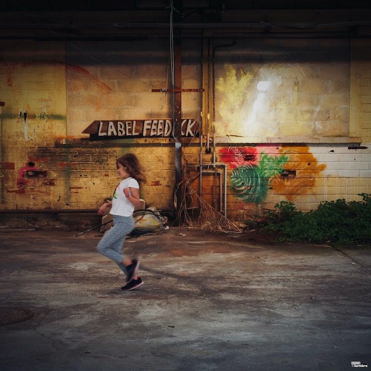 Enfant courant dans une ancienne usine. Photo : Antoine Fantin "Encre & Lumière"