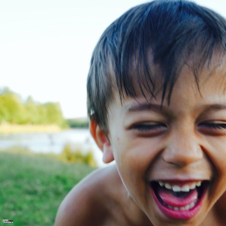 Garçon de 5 ans éclatant de rire. Photo floue.