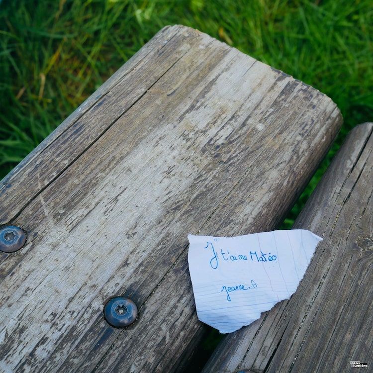 Mot d'amour écrit par un enfant et posé sur banc public '"Je t'aime Matéo"