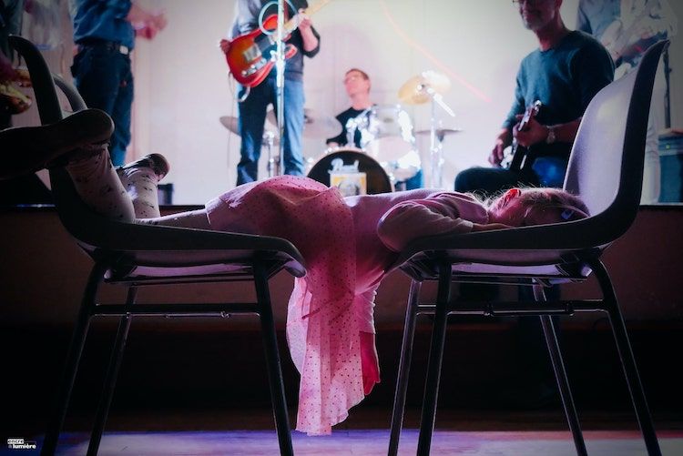 Enfant endormi à un concert de rock, allongé sur deux chaises. Photo ambiance concert festival événement normandie.