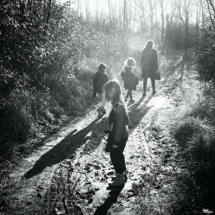 Enfants marchant dans la campagne à contre-jour.