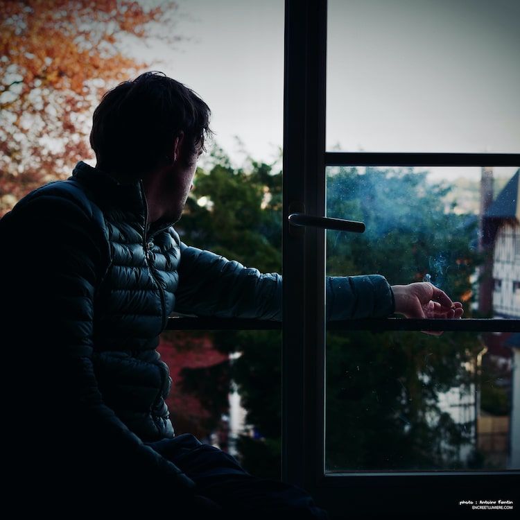 Jeune homme fumant une cigarette à la fenêtre. Série "À la fenêtre" de Antoine Fantin