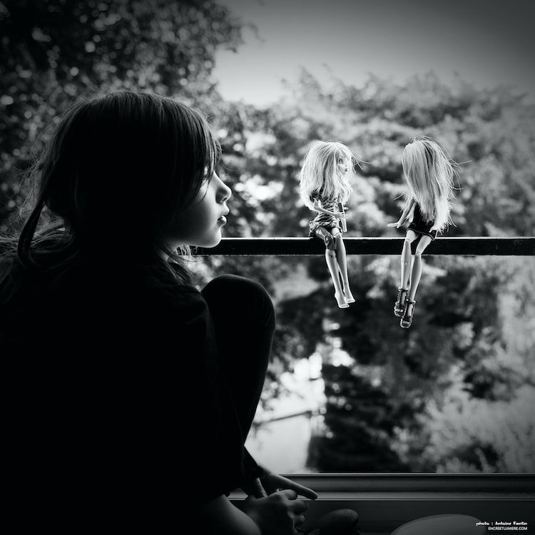 Enfant jouant avec des poupes Monster High à la fenêtre. Photo confinement. Série "À la fenêtre" de Antoine Fantin