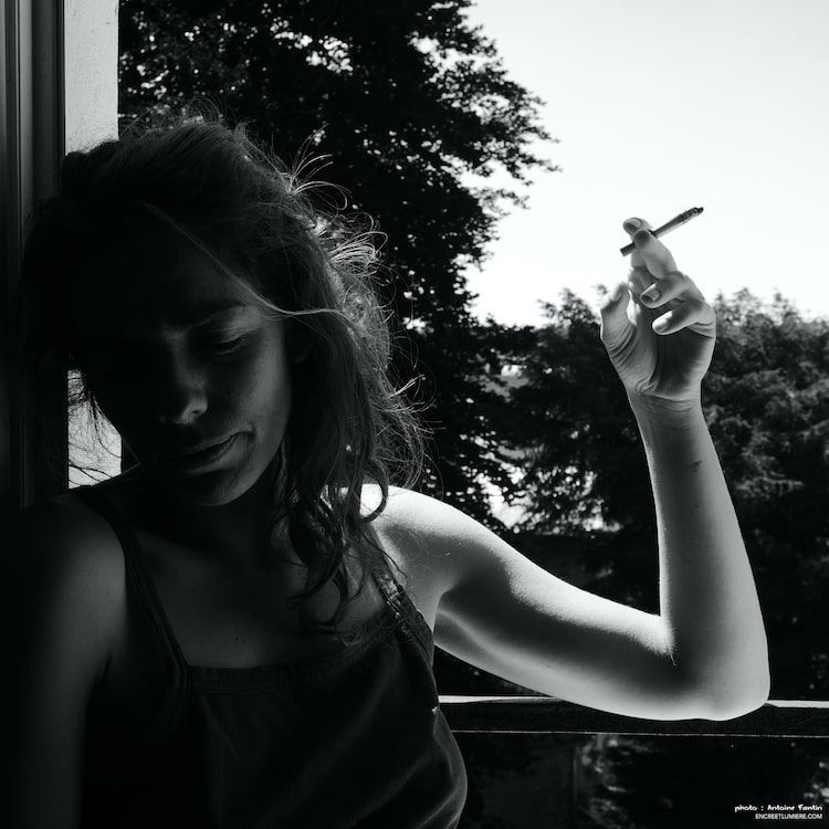 Jeune femme fumant une cigarette à la fenêtre. Série "À la fenêtre" de Antoine Fantin