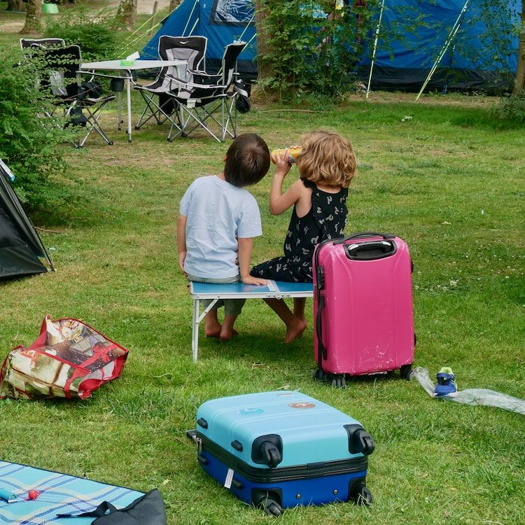Enfant de 8 ans assise à l'arrière d'un van surchargée. Photo voyage, sur la route.