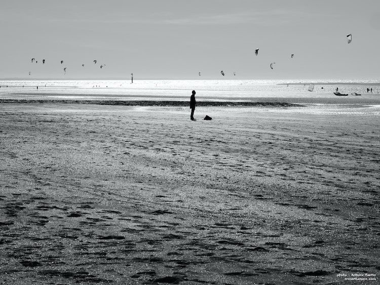 Silhouette d'un homme sur la plage avec des cerfs-volants dans le ciel. Houlgate.