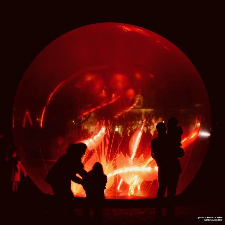 Boule rouge avec silhouettes noires devant.